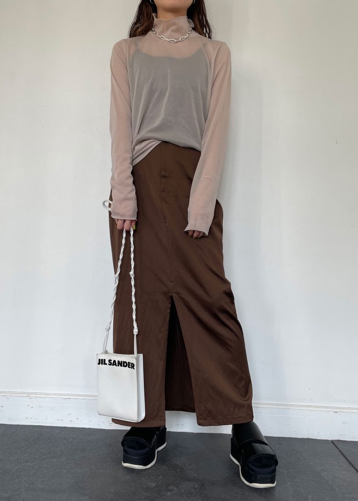 2021年トレンドのシアーメロートップスは優秀すぎるアイテム！ 通気性に優れているので、インナーをキャミソールにして暑い日も着用可能。 ボトムスはサテン素材のブラウンスカートを合わせて、より秋の季節感が高まる着こなしに◎