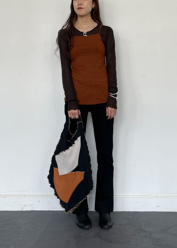 シアーメロートップスにブラウンのキャミソールを重ね着して、全体的にブラックとブラウンでまとめた秋コーデ。 色味にまとまりがあると、スッキリとした印象になり、よりおしゃれ見え◎