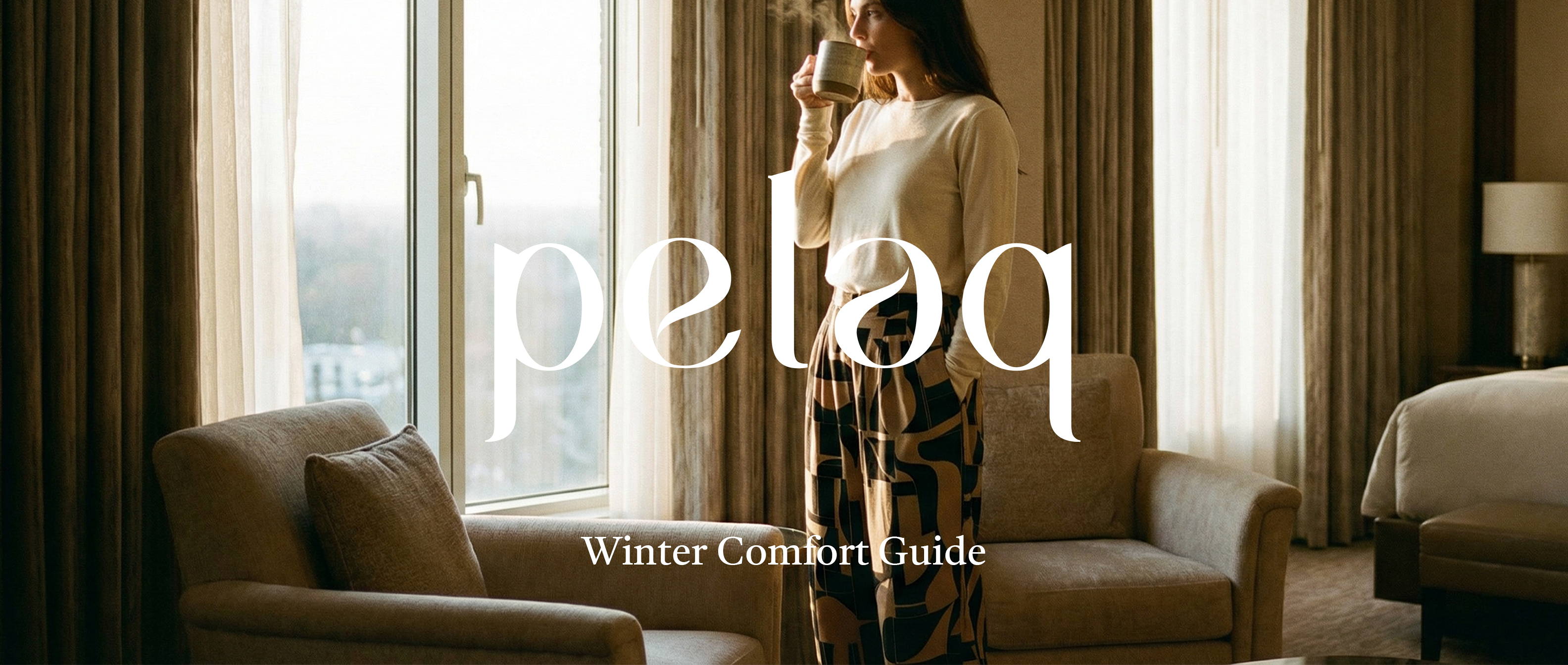 ヘッダー用：秋冬の自然光が入る静かな室内。ニュートラルカラーなベージュのセーターを着てペラクスパンツを着用した女性が、温かいドリンクを片手に佇んでいる