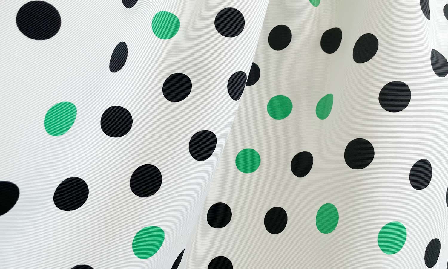 馴染みやすいホワイトにグリーンとブラックのドット柄がプリントされた神戸・山の手ドット柄スカート　グリーン×ブラック