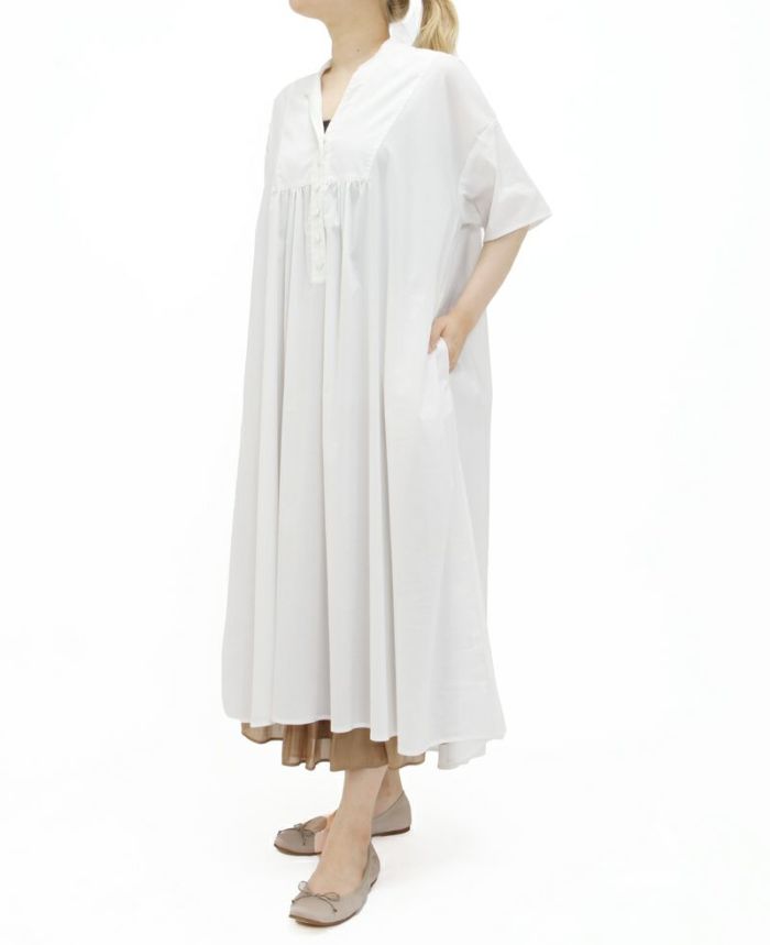 光沢のあるゴールドのドレープギャザーロングスカート。ホワイトのワンピースを重ねた秋コーディネート。