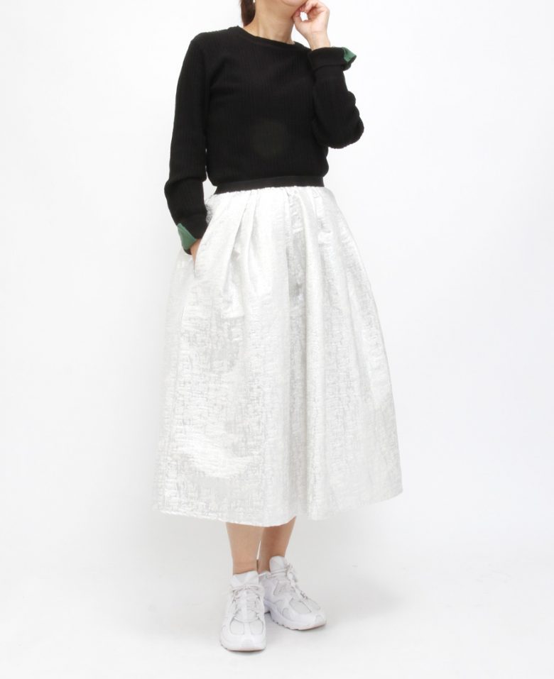 ジャガード調のミモレ丈メタリックシルバースカートとクルーネックのブラックトップスを合わせたコーディネート。