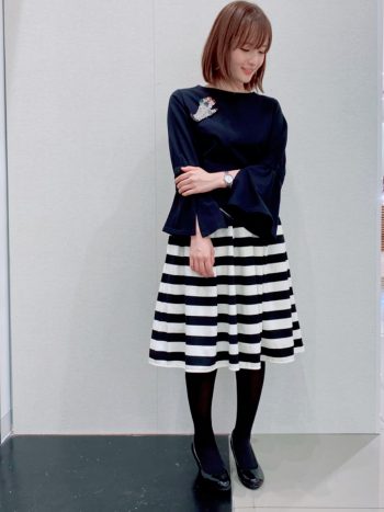 ブラックのフレアスリーブコットンカットソーにボーダースカートとタイツを合わせたコーディネート。