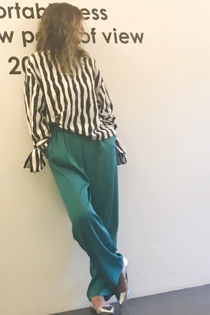 ストライプブラウスに艶感の美しいグリーンのパンツを合わせたエッジィなコーデには、シルバーのポインテッドトゥのシルバーパンプスでさらに大人の女性に。