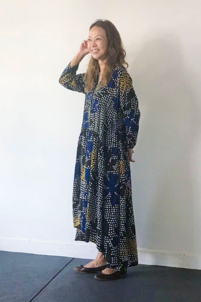 ドットフラワーモチーフがプリントされたワンピースとネイビーのパイピングを施したスムース素材のブラウンのラウンドトゥバレエシューズの秋コーデです。