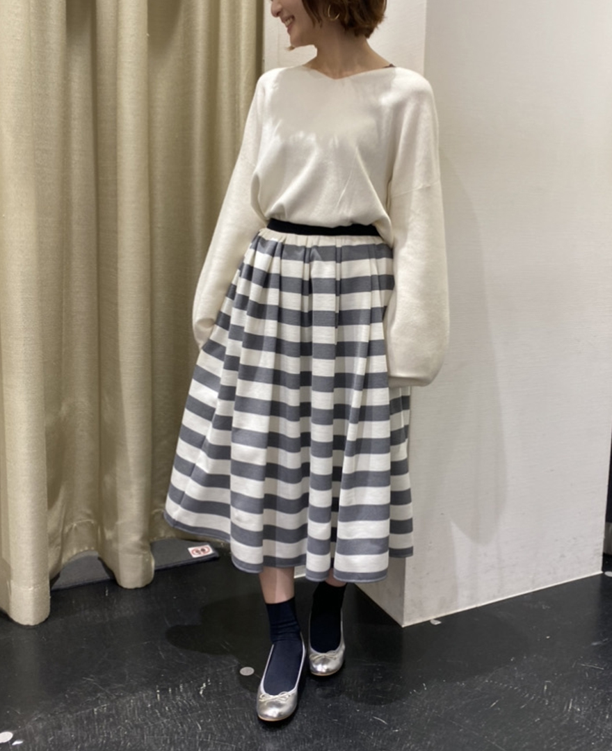 ホワイトのもちもちニットとグレーのボーダーフレアスカートを合わせたガーリーなコーディネート