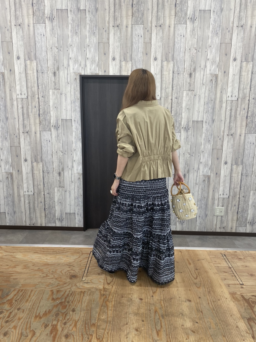 ベージュのジャケットとパンチングスカートのコーディネート(後ろ姿)