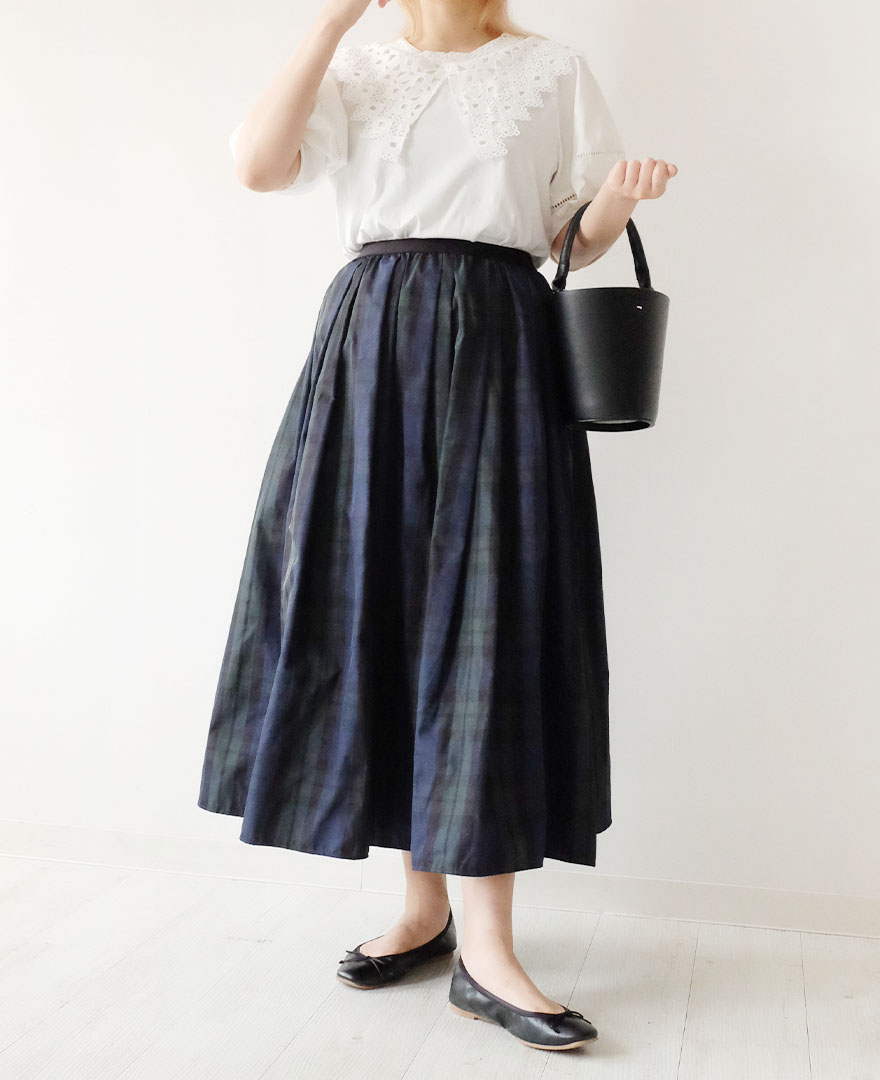 大きいレースの襟がついたホワイトのTシャツに、タータンチェックのマキシ丈スカートをコーディネート