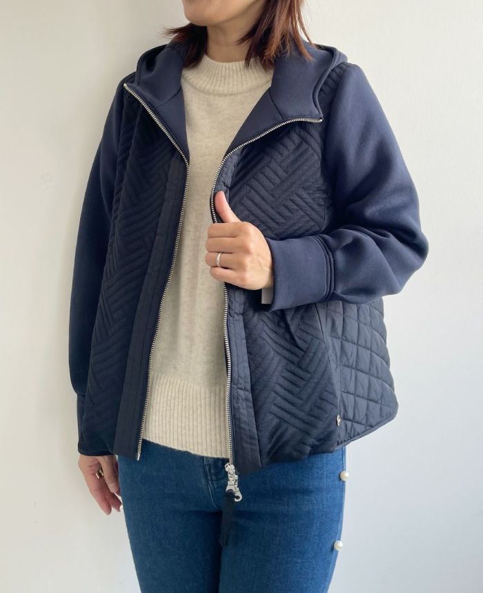 3つの異なる生地感がドッキングしたキルティングショートコート。フード付で一見カジュアルな見た目ですが、マットな質感が高級感をプラス。前ファスナーは上からも下からも上げ下げできるダブルジップ仕様。